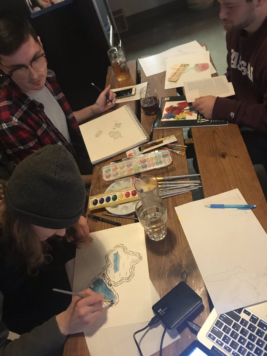 people gather at table using water color to map